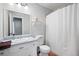 Bright bathroom with white vanity, toilet, shower with curtain, and a large mirror at 975 Malibu Dr, Marietta, GA 30066