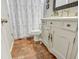 Quaint bathroom featuring brick flooring, vintage vanity, and a shower with a patterned curtain at 102 Rosebury Dr, Canton, GA 30115