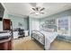 Well-lit bedroom featuring a bed, ceiling fan, and a functional desk area at 102 Rosebury Dr, Canton, GA 30115