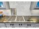 Close-up of kitchen cooktop featuring granite countertops, modern tile backsplash and custom cabinetry at 102 Rosebury Dr, Canton, GA 30115
