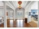 A foyer is brightened by glass double doors and a decorative chandelier at 102 Rosebury Dr, Canton, GA 30115