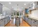 Open-concept kitchen with an island, stainless steel appliances, and hardwood flooring throughout the home at 102 Rosebury Dr, Canton, GA 30115