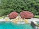 Close up of the backyard pool with rock waterfall and lush landscaping at 102 Rosebury Dr, Canton, GA 30115