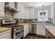 Modern kitchen featuring stainless steel appliances, granite countertops, a stylish backsplash, and white cabinetry at 1205 Club Walk Ne Dr, Brookhaven, GA 30319