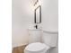Modern half bathroom features a sleek mirror, contemporary lighting, and stylish fixtures at 594 Waynes Se Ct, Atlanta, GA 30354