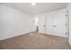 A bright bedroom offers neutral carpet, white walls, and entry to a bathroom at 594 Waynes Se Ct, Atlanta, GA 30354