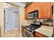 Galley kitchen featuring wood cabinets, granite countertops, stainless steel appliances and travertine flooring at 799 Hammond Dr # 305, Atlanta, GA 30328