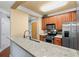Open-concept kitchen offering granite countertops, stainless steel appliances, and dark-wood cabinets at 799 Hammond Dr # 305, Atlanta, GA 30328