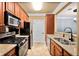 Galley kitchen featuring wood cabinets, granite countertops, stainless steel appliances and travertine flooring at 799 Hammond Dr # 305, Atlanta, GA 30328