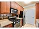 Galley kitchen featuring wood cabinets, granite countertops, stainless steel appliances and travertine flooring at 799 Hammond Dr # 305, Atlanta, GA 30328
