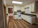 Functional kitchen with white appliances, cabinets, and granite countertops at 137 Bonnie Nw Ln, Lilburn, GA 30047