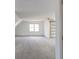 Carpeted bonus room features a ceiling fan, natural light, and barn door at 1931 Amber Dawn Way, Lawrenceville, GA 30043