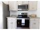Well-equipped kitchen featuring granite countertops, white cabinets, and modern stainless steel appliances at 1931 Amber Dawn Way, Lawrenceville, GA 30043