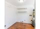 Unfinished utility room with wood flooring, shelving and a water heater for storage and utilities at 1931 Amber Dawn Way, Lawrenceville, GA 30043