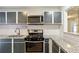 Kitchen showcasing granite counters, sleek cabinetry, and stainless steel gas range with microwave above at 2701 Cumberland Se Ct, Smyrna, GA 30080
