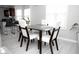 Bright dining room featuring a glass table with seating for four and a partial view into the kitchen at 5895 Water Oaks Dr, Austell, GA 30106