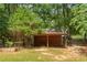 Red outbuilding on a grassy lot with mature trees at 2170 Leguin Mill Rd, Locust Grove, GA 30248