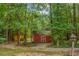 Property featuring a red outbuilding in a wooded area at 2170 Leguin Mill Rd, Locust Grove, GA 30248