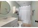 Cozy bathroom featuring a single sink vanity, round mirror, and a shower with a white curtain at 4465 Newhall Dr, Cumming, GA 30040