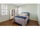 Bedroom featuring hardwood floors, two windows, a white armoire, and a bed with blue accents at 4465 Newhall Dr, Cumming, GA 30040