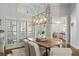 Well-lit dining room with wooden table, shuttered windows, and elegant light fixture at 4465 Newhall Dr, Cumming, GA 30040