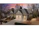 Beautiful two-story home featuring a three-car garage and covered front porch at sunset at 4465 Newhall Dr, Cumming, GA 30040