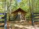 Wood footbridge leading to the walking trails in a quiet, wooded community, framed by black fencing at 4465 Newhall Dr, Cumming, GA 30040