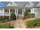 Inviting front entrance with stone pathway, landscaped bushes, and a covered porch at 4465 Newhall Dr, Cumming, GA 30040