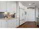 Detailed view of the kitchen showcasing custom white cabinets and stone countertops at 4465 Newhall Dr, Cumming, GA 30040