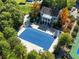 Aerial view of community pool covered for the season, surrounded by trees and a charming pool house at 4465 Newhall Dr, Cumming, GA 30040