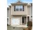 Charming townhome featuring beige siding, a garage, and black shutters at 1112 Highwood Ln, Atlanta, GA 30344