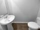 Half bathroom with a pedestal sink, toilet, and hardwood style flooring at 1112 Highwood Ln, Atlanta, GA 30344