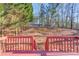 View of the backyard from a red wood deck with a sloped lawn and mature trees at 3110 Chandon Ln, Lawrenceville, GA 30044