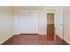 Spacious bedroom featuring pristine wood floors, a large closet, and an open doorway at 3110 Chandon Ln, Lawrenceville, GA 30044