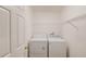 Laundry room with standard washer and dryer, overhead wire shelf, and a white door at 3110 Chandon Ln, Lawrenceville, GA 30044