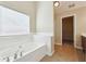 Large tub inside of a bathroom with tile and a walk in closet in the back at 1309 Avington Glen Dr, Lawrenceville, GA 30045