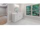 Bright bathroom with a white vanity, round mirror and a large window overlooking greenery at 304 Trecastle Ln # 28, Canton, GA 30114