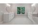 Dual vanities, each with a round mirror, plus large window and soaking tub in a bright, neutral bathroom at 304 Trecastle Ln # 28, Canton, GA 30114