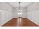 Formal dining room boasts wainscoting, hardwood flooring, and an elegant modern chandelier at 304 Trecastle Ln # 28, Canton, GA 30114