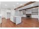 Open floor plan showcasing a kitchen island, brick fireplace, hardwood floors, and wood beams at 304 Trecastle Ln # 28, Canton, GA 30114