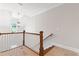 Staircase with wood railing and white spindles, lit by modern chandelier and large window at 304 Trecastle Ln # 28, Canton, GA 30114
