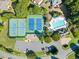 Aerial view of community tennis courts, swimming pool, and parking lot with ample green space at 511 Newburgh Way, Roswell, GA 30075
