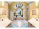 Bright primary bathroom featuring vaulted ceiling, tub under arched window, and dual vanities with a decorative chandelier at 511 Newburgh Way, Roswell, GA 30075