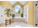Bright primary bathroom showcasing a soaking tub below an arched window, and neutral tile flooring at 511 Newburgh Way, Roswell, GA 30075