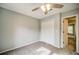 Bedroom featuring plush carpet, ceiling fan and double-door closet and open door to hallway at 511 Newburgh Way, Roswell, GA 30075