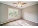 Cozy bedroom with ceiling fan and carpeted floors and window overlooking trees at 511 Newburgh Way, Roswell, GA 30075