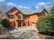 Elegant two-story home featuring an attached garage, arched windows and a stone entry set among mature landscaping at 511 Newburgh Way, Roswell, GA 30075