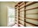 Built-in, natural wood shelving next to window with lots of storage and natural light at 511 Newburgh Way, Roswell, GA 30075