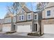 Beautiful two-story townhome boasts a well-maintained lawn, gray siding, and a convenient two-car garage at 686 Smokey Quartz Way, Kennesaw, GA 30144
