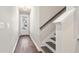 Entrance hallway featuring hardwood floors, white walls, and a staircase with dark wood steps at 686 Smokey Quartz Way, Kennesaw, GA 30144